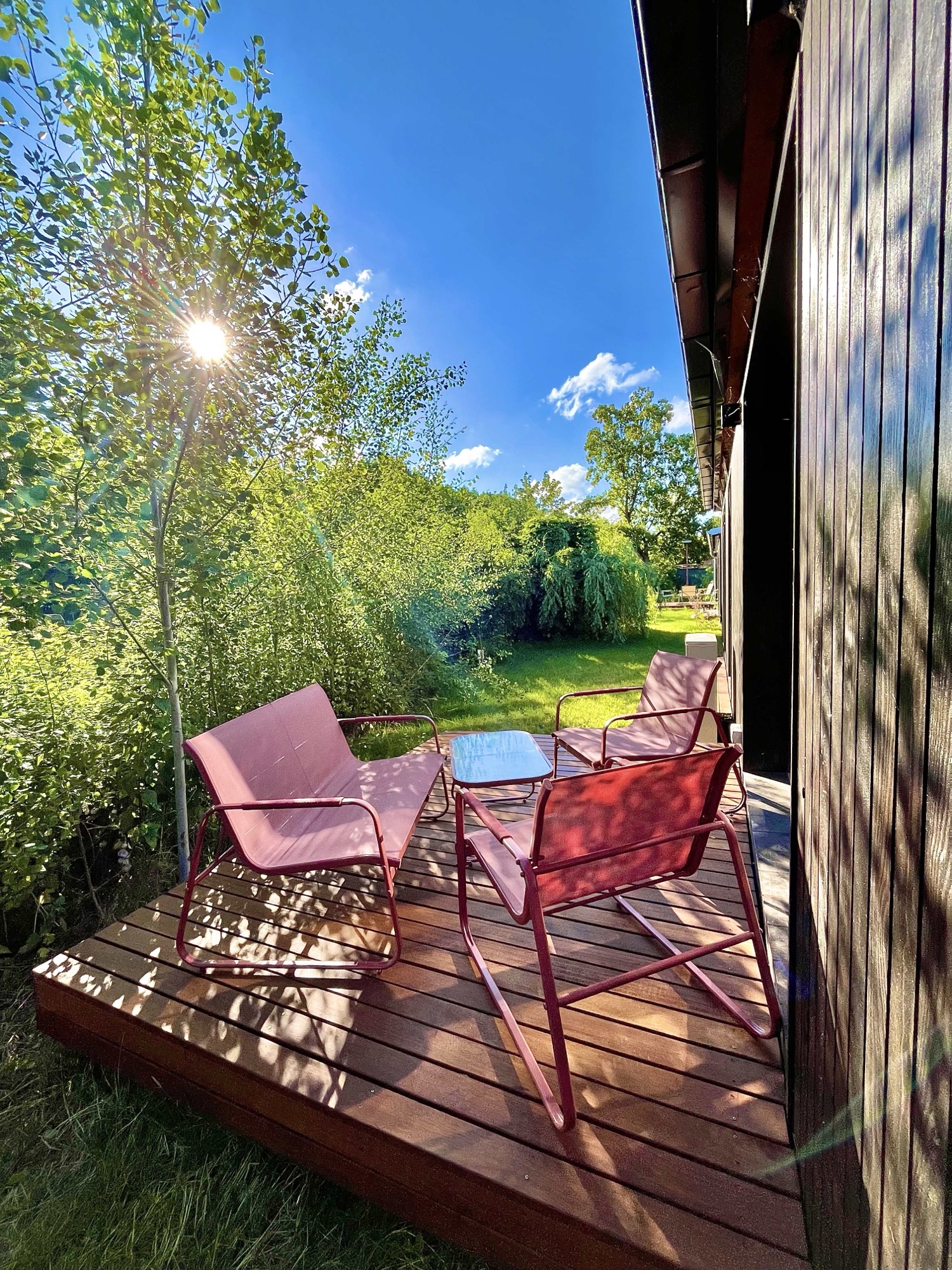 Terrasse mit Stühlen im Gegenlicht am Waldrand