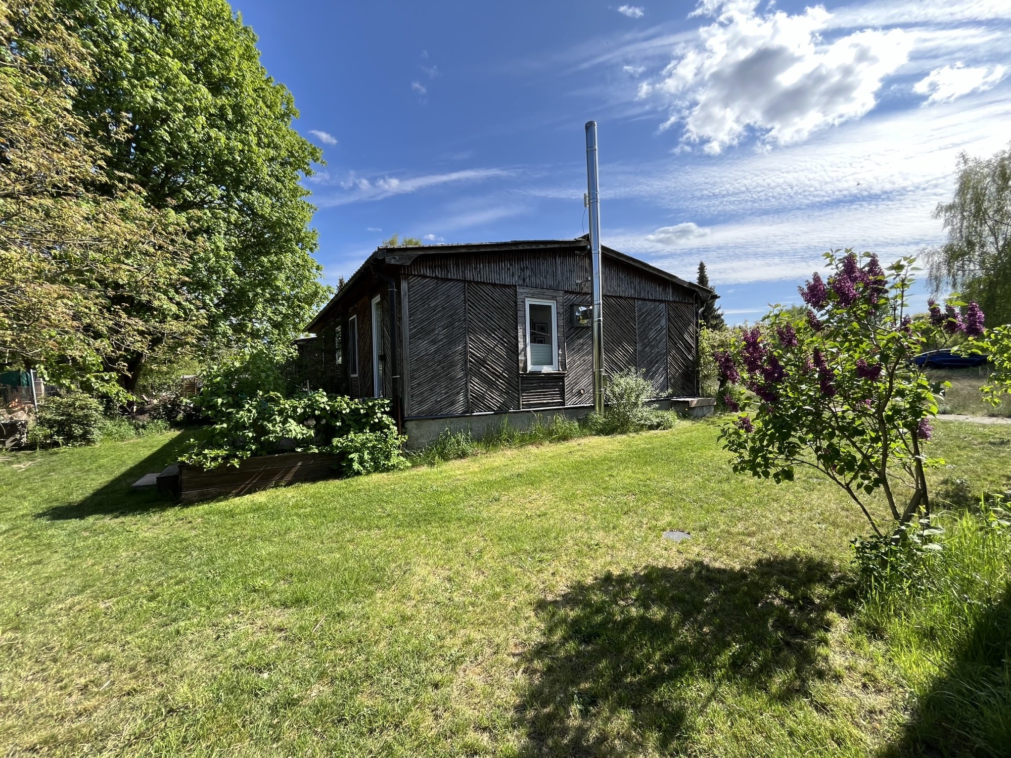 Haus 8 im Garten mit blühendem Flieder