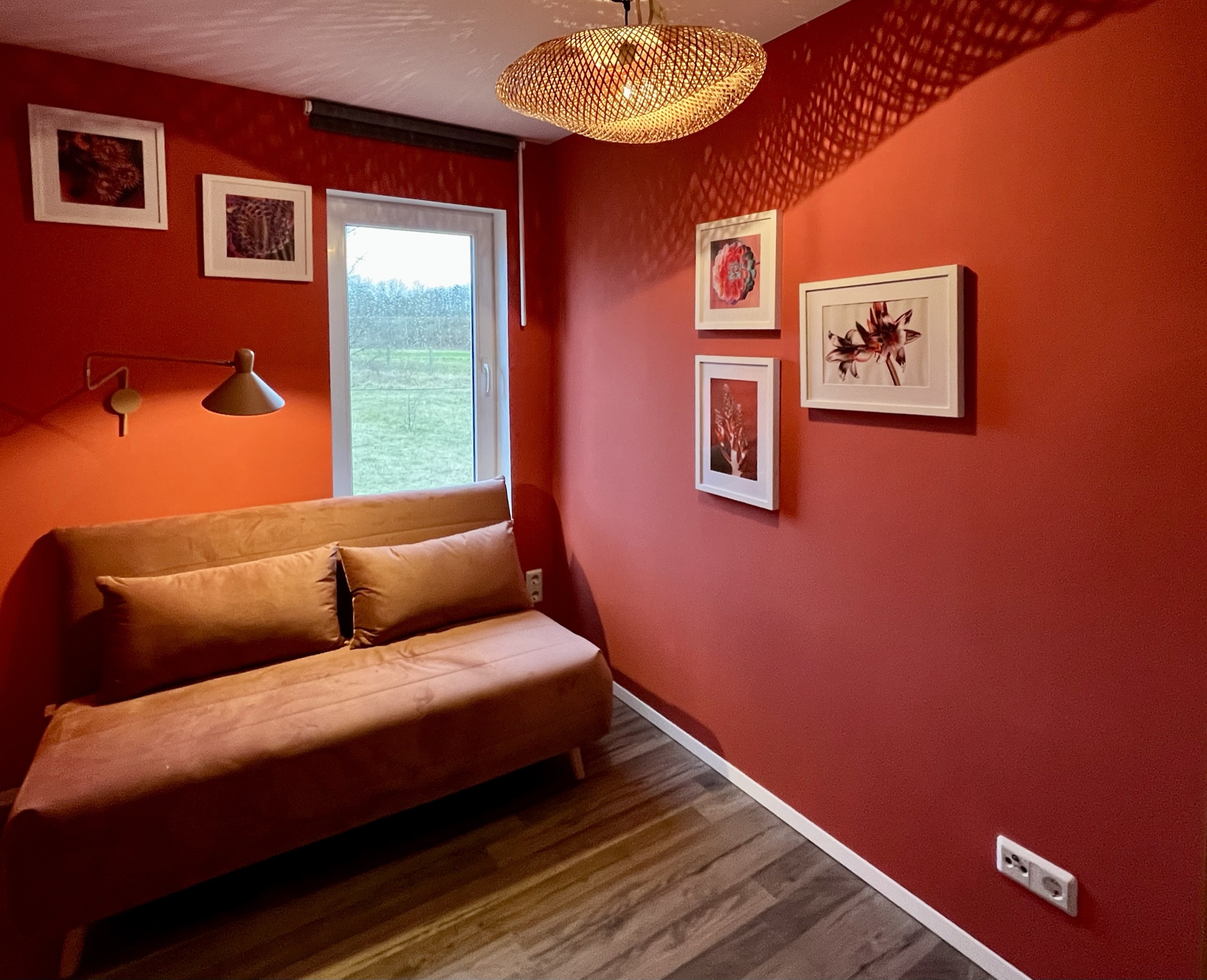 Ledersofa vor roter Wand mit Bildergalerie